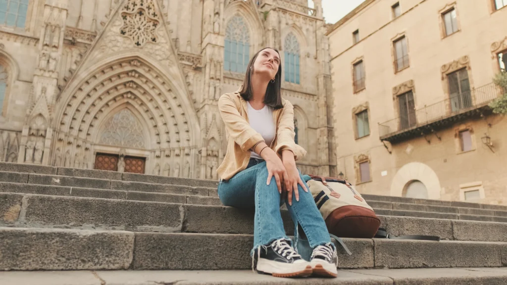 Woman sitting in front of a cathedral in Europe